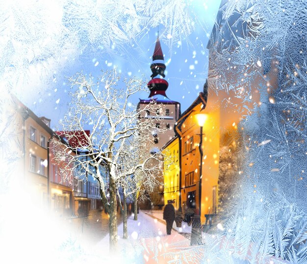 Winterstadtmenschen gehen auf schneebedeckten Straßenbäumen, die in der mittelalterlichen Altstadt am Abend von Schnee bedeckt sind