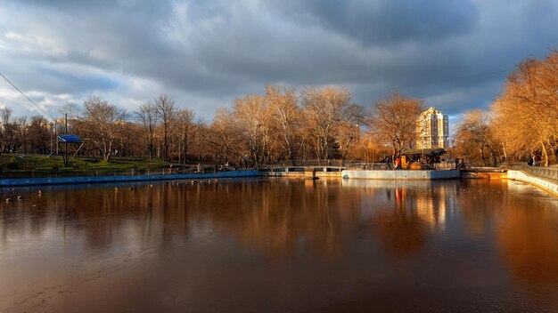 Foto winterstadtpark mit gefrorenem see bewölkter himmel schönes abendlicht