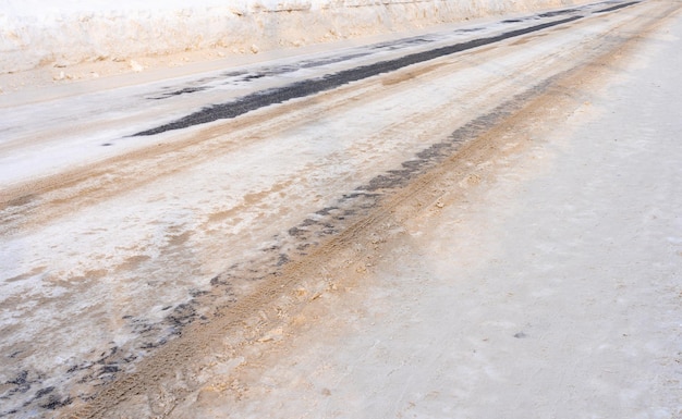 Winterstraße mit Schnee bedeckt und mit Sand bestreut