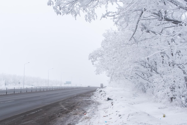 Winterstraße und Schnee mit Baumlandschaft mit Frost