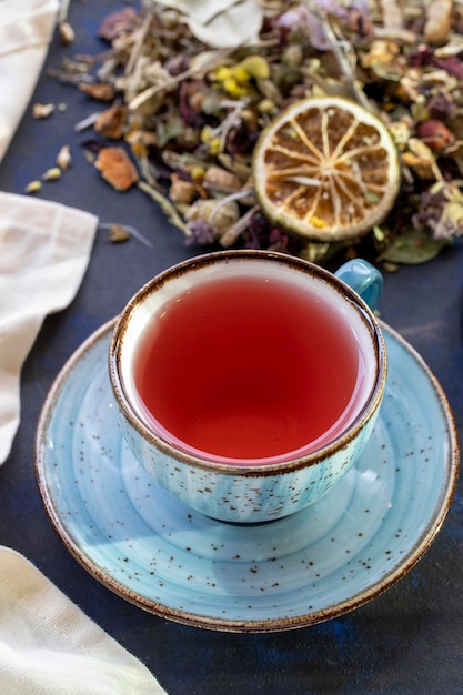 Wintertee in einer Tasse auf schwarzem und blauem Hintergrund