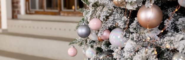 Winterurlaub Zusammensetzung Weihnachtsbaum Tannenzweige silberne Kugeln rosa Pastell Ornamente Weihnachten