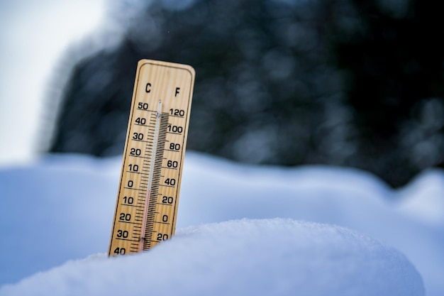 Winterzeit-Thermometer auf Schnee zeigt niedrige Temperaturen in Celsius