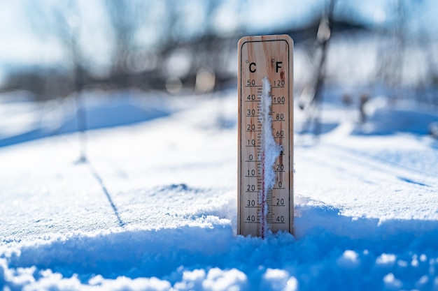 Winterzeit-Thermometer auf Schnee zeigt niedrige Temperaturen in Celsius