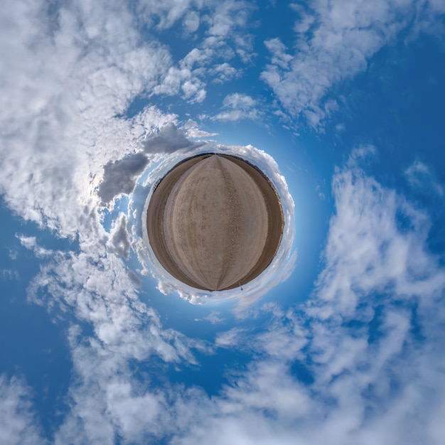 Foto winziger planet im blauen himmel mit schönen wolken mit transformation des sphärischen panoramas 360 grad sphärische abstrakte luftaufnahme krümmung des weltraums