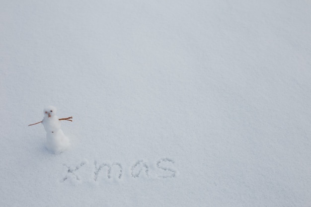 Winziger Schneemann im Schnee Textfreiraum Text Weihnachten im SchneeFrohe Weihnachten und ein frohes neues Jahr Grußkarte