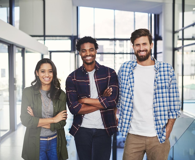 Wir glauben, das waren die Besten der Branche Porträt von drei jungen Designern, die zusammen in einem modernen Büro stehen