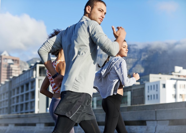 Wir schubsen uns gegenseitig weiter Aufnahme einer Gruppe von Freunden, die gemeinsam durch die Stadt joggen