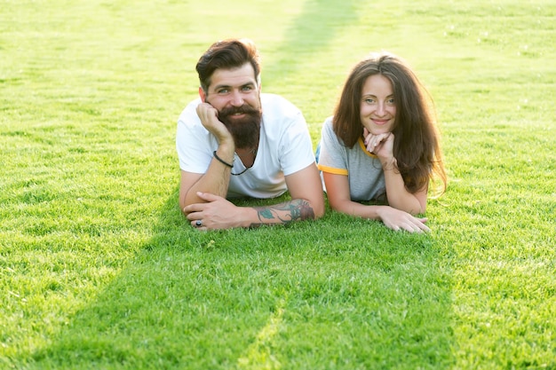 Wir sind aus Glückliches Paar auf grünem Gras entspannen Verliebtes Paar Sommer im Freien Sexy Paar in Freizeitkleidung Paar sinnliche Mädchen und Hipster Freund und Freundin Liebe und Romantik