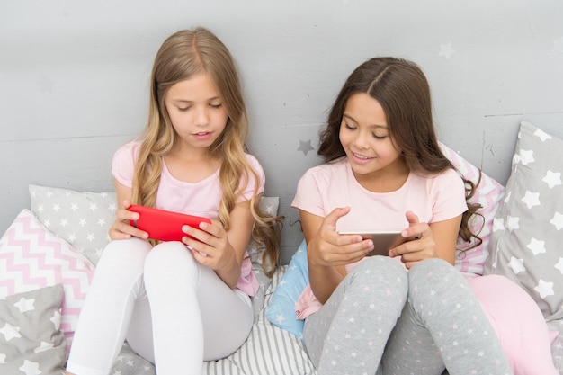 Wir sind vernetzter denn je Kleine Kinder telefonieren im Bett Mobilkommunikation Mobilfunkkommunikation Kommunikationstechnik SMS-Kommunikation Modernes Leben