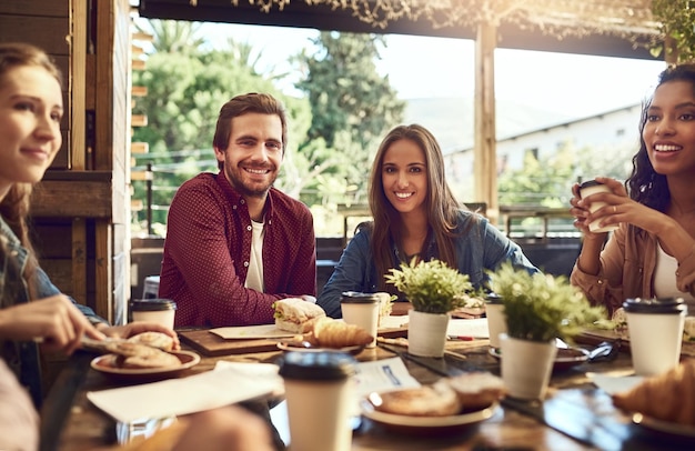 Wir waren den Freunden dankbar, die uns angeschlossen haben Zugeschnittenes Porträt eines liebevollen jungen Paares, das mit Freunden in einem Café zu Mittag isst