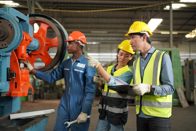 Wirtschaftsingenieure in Hard HatsWork in der Heavy Industry Manufacturing FactoryIndustriearbeiter drinnen in einem Fabrikmann, der in einer Industriefabrik arbeitet