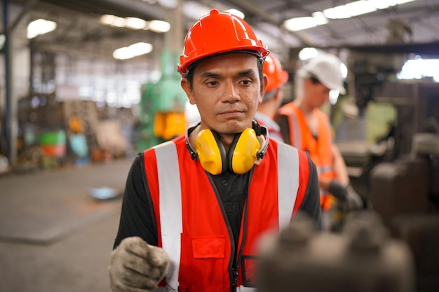 Wirtschaftsingenieure in Hard HatsWork in der Heavy Industry Manufacturing FactoryIndustriearbeiter drinnen in einem Fabrikmann, der in einer Industriefabrik arbeitet