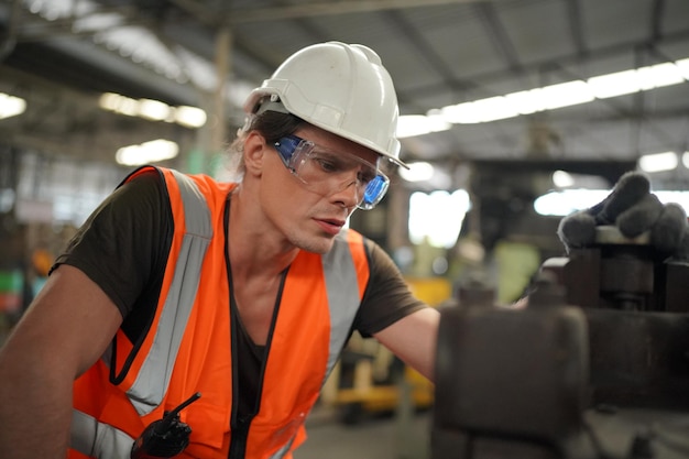 Wirtschaftsingenieure in Hard HatsWork in der Heavy Industry Manufacturing FactoryIndustriearbeiter drinnen in einem Fabrikmann, der in einer Industriefabrik arbeitet