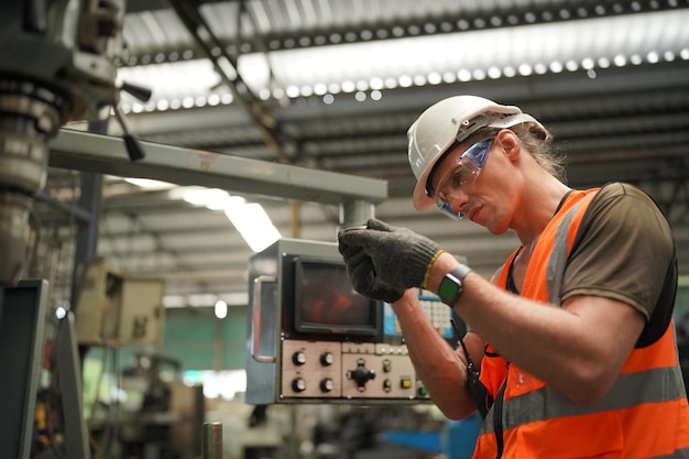 Wirtschaftsingenieure in Hard HatsWork in der Heavy Industry Manufacturing FactoryIndustriearbeiter drinnen in einem Fabrikmann, der in einer Industriefabrik arbeitet