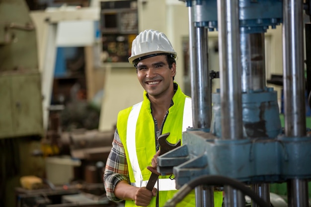 Wirtschaftsingenieure in Schutzhelmen. Arbeiten Sie in der Schwerindustrie-Manufakturfabrik. Industriearbeiter drinnen in der Fabrik. Alter Mann, der in einer Industrie arbeitet