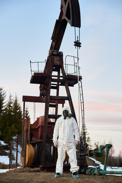 Wissenschaftler, der in der Nähe von Ölbrunnenpumpenheber steht