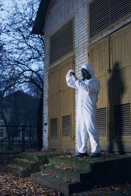 Wissenschaftler forschen im Freien mit weißem Overall und Gasmaske