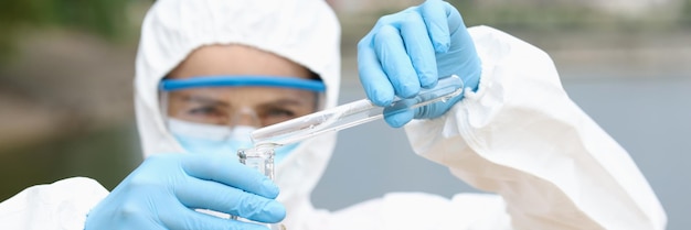 Wissenschaftler oder Biologe entnimmt eine Wasserprobe in der Nähe einer Wasserprobe in einer Industrieanlage in Chemie