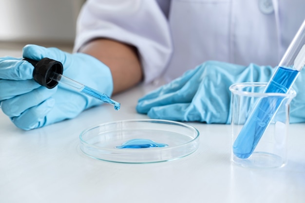 Wissenschaftler oder Mediziner im Laborkittel, der das Reagenzglas mit Reagenz hält