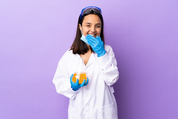 Wissenschaftlerin, die einen Impfstoff untersucht, um Krankheit glücklich und lächelnd Mund mit Hand zu heilen