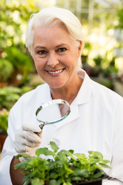 Wissenschaftlerin, die Pflanzen mit Lupe untersucht