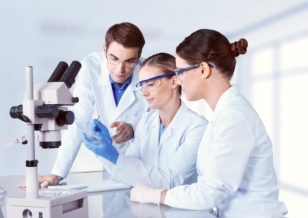 Wissenschaftlerinnen und Wissenschaftler in Brillen, die mit dem Mikroskop arbeiten