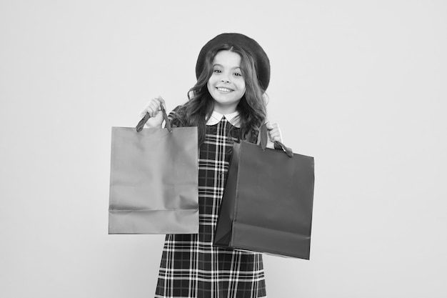 Wo Mode zum Leben erwacht Einkaufstag Glückliches Kind hält Pakete Mädchen mit Einkaufstasche Sparen Sie Geld
