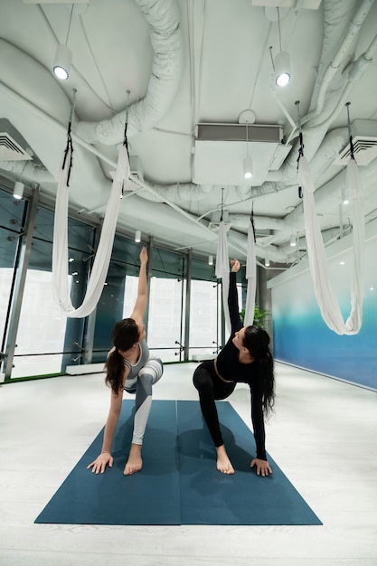 Wochenend-Yoga. Zwei dunkelhaarige Schwestern fühlen sich großartig beim gemeinsamen Yoga am Wochenende