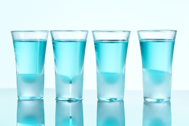 Wodkaglas mit Eis auf blauem Studiohintergrund