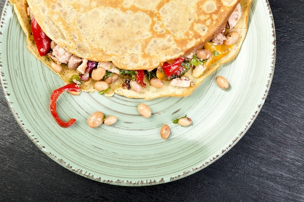 Wohlschmeckender Buchweizen-Pfannkuchen mit weißen Bohnen, rotem und gelbem grünem Pfeffer, Petersilie und Huhn