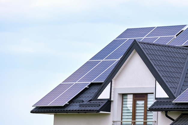 Wohnhaus mit Dach, das mit Solar-Photovoltaik-Paneelen zur Erzeugung sauberer ökologischer elektrischer Energie in einem ländlichen Vorort bedeckt ist Konzept des autonomen Hauses