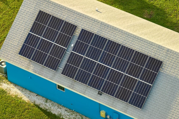 Wohnhaus mit Dach, das mit Solar-Photovoltaik-Paneelen zur Erzeugung sauberer ökologischer elektrischer Energie in einem ländlichen Vorort bedeckt ist Konzept des autonomen Hauses