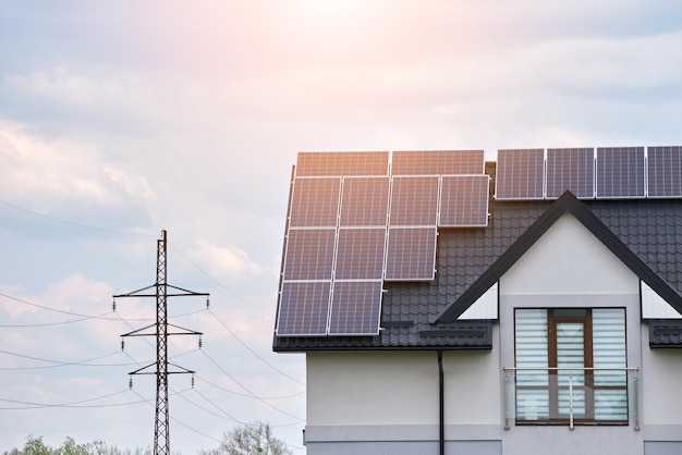 Wohnhaus mit Dach, das mit Solar-Photovoltaik-Paneelen zur Erzeugung sauberer ökologischer elektrischer Energie in einem ländlichen Vorortgebiet bedeckt ist. Konzept des autonomen Zuhauses.