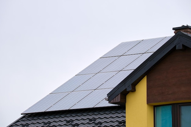 Wohnhaus mit mit Sonnenphotovoltaik-Panelen überdachtem Dach zur Erzeugung sauberer ökologischer elektrischer Energie in ländlichen Vorstädten Konzept des autonomen Hauses