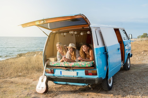 Wohnmobil geparkt an einem Strand mit Freunden, die drinnen liegen