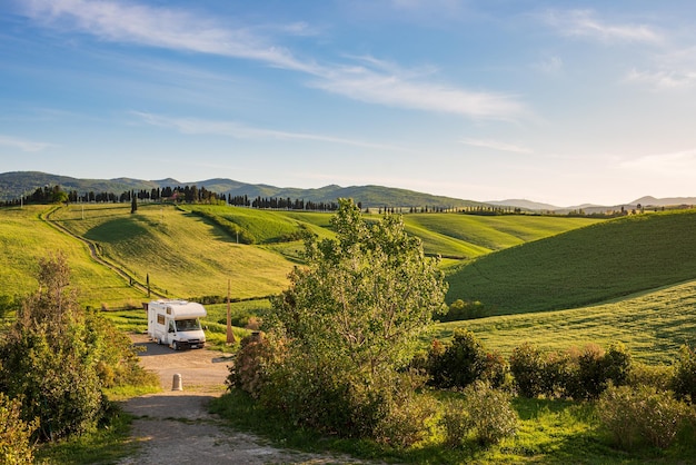 Wohnmobil in einzigartiger grüner Landschaft Vanlife in der Toskana Italien Szenischer dramatischer Himmel und Sonnenuntergang über kultivierten Hügelketten und Getreidefeldern Toscana Italia