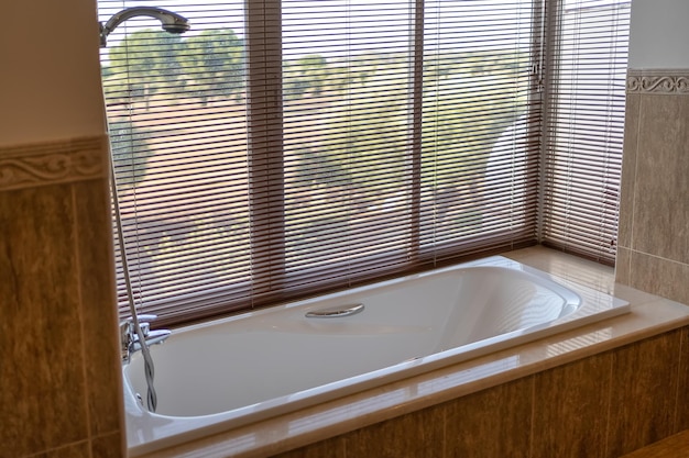 Wohnung Badewanne umgeben von Glas mit Blick auf den Wald an einem sonnigen Tag