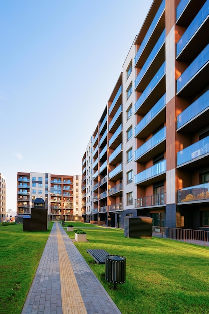 Wohnungen Wohnhaus Fassade Architektur und Außenanlagen. Blauer Himmel im Hintergrund.