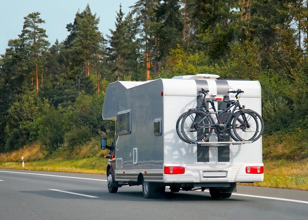 Wohnwagen mit Fahrrädern auf der Autobahn in der Schweiz.