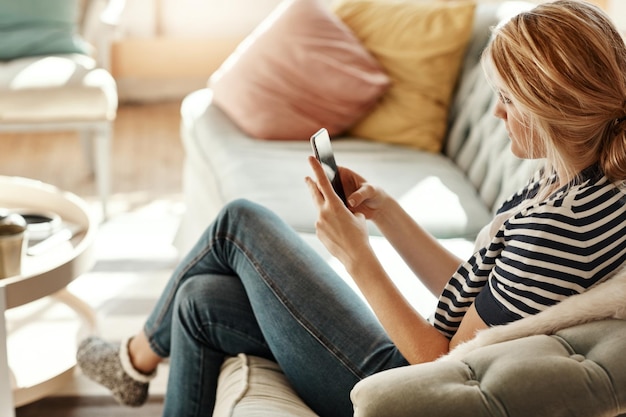 Wohnzimmer einer Frau und Telefontippen einer Person auf einem Sofa mit WLAN, die mit sozialen Medien beschäftigt ist Hausfrau und mobiles Online-Lesen oder Scrollen, Tippen mit Konnektivität und Mobiltelefonkommunikation