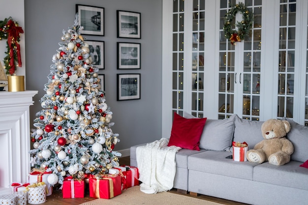 Wohnzimmer mit Kamin und Weihnachtsbaum mit Geschenken im modernen Stil. Foto in hoher Qualität