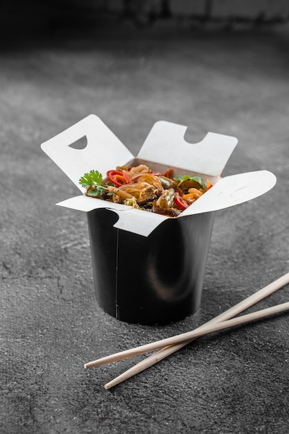 Wok em caixa de macarrão de arroz em recipiente preto para comida