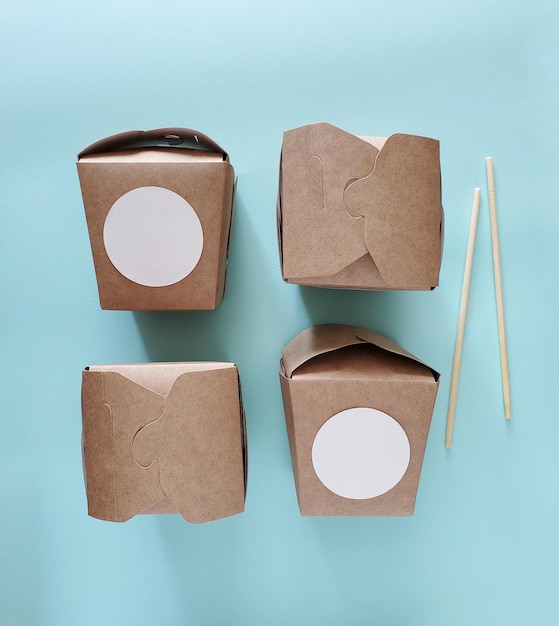Wok-Nudeln Papierschachteln Konzept Chinesische Lebensmittelverpackungen auf blauem Hintergrund