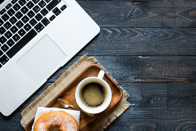 Woking desk table com composição de café da manhã coloridos donuts