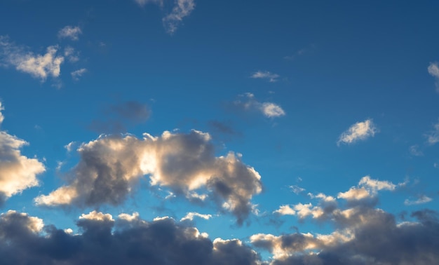 Wolken im blauen Himmel, die mit Sonnenlicht glänzen