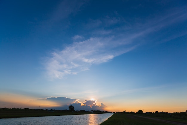 Wolken mit Reflexion über den Fluss bei Sonnenuntergang oder Sonnenaufgang