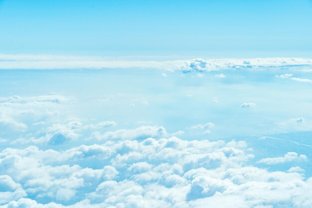 Wolken und Himmel oben aus dem Fenster des Flugzeugs