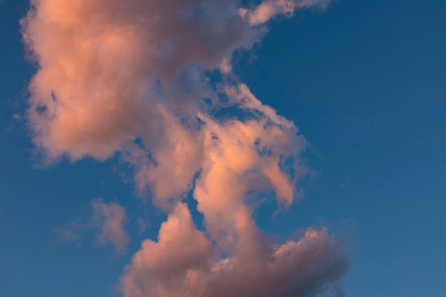 Wolkenlandschaft Rosa und braune Sommerwolken auf einem blauen Himmel während des Sonnenuntergangs Wallpaper Background