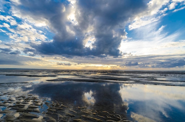 Wolkenreflexionen im stillen Ozean von der Strandbucht von Saint Michel in der Normandie